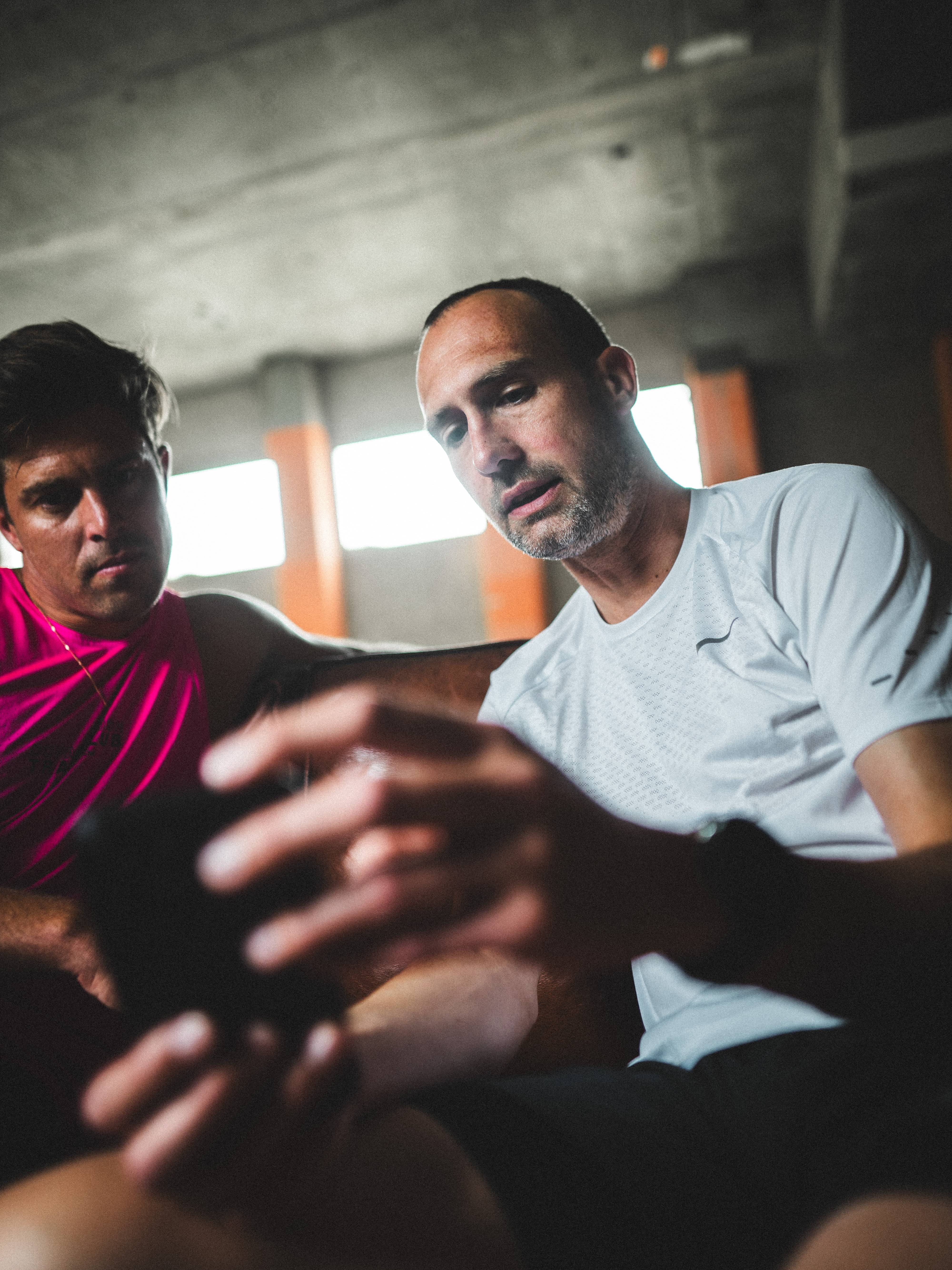 Two men discussing REN app features on mobile phone