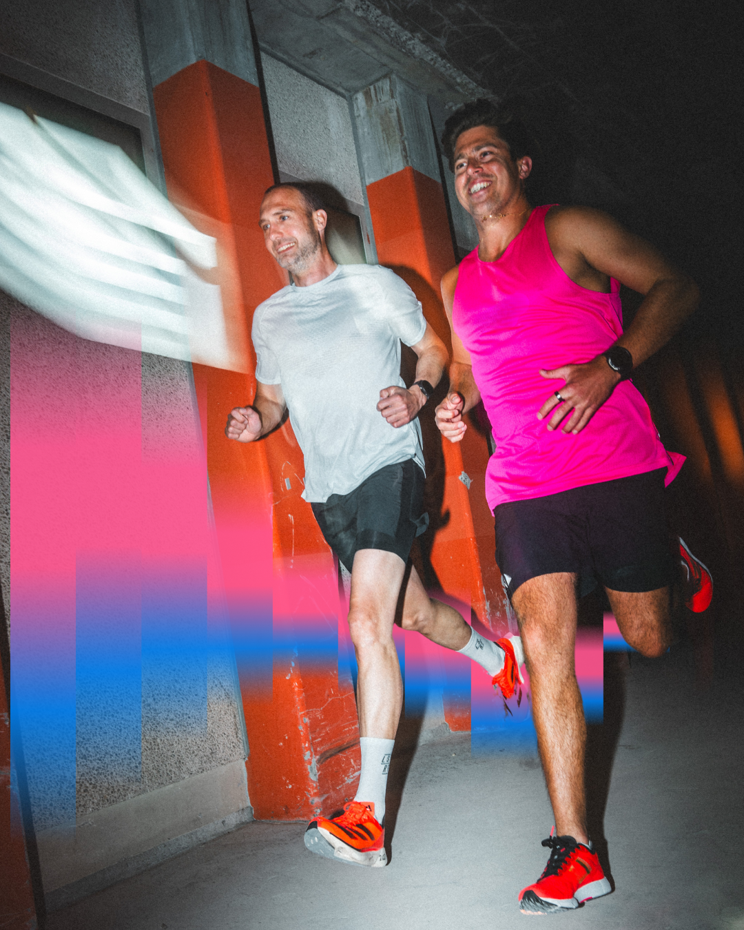 Two runners training together in urban setting with vibrant lighting